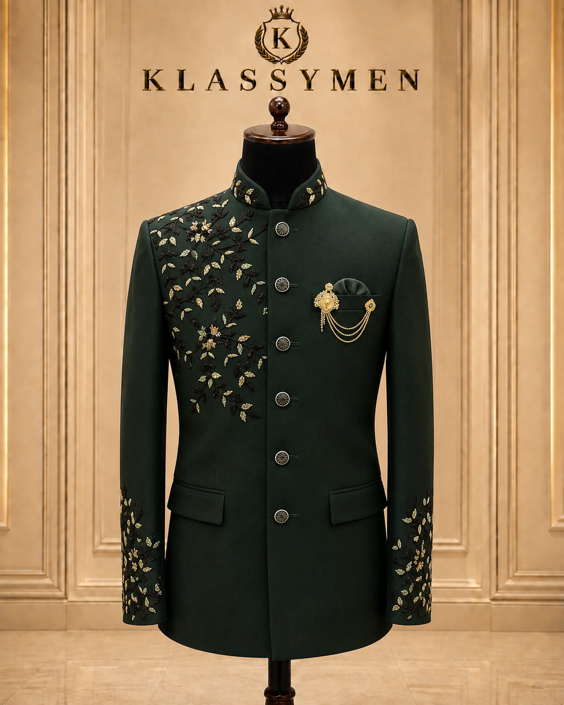 A dark green traditional men's jacket displayed on a mannequin torso against a beige paneled wall. The jacket features gold floral embroidery on the chest and cuffs, a mandarin collar, and decorative gold embroidery and brooch on the left chest.
